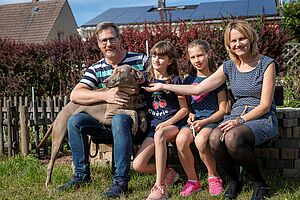 Foto zeigt Familie Fiege mit Hund im Garten.