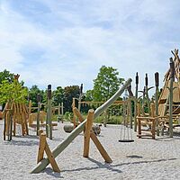 Foto zeigt einen Spielplatz mit zahlreichen Spielgeräten und Klettergerüsten aus Holz in der Stadt Roßwein.