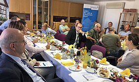 Foto zeigt Impression vom mittelsächsischen Unternehmerfrühstück bei der Firma Schreiter & Kroll in Waldheim. Unternehmer im Gespräch miteinander.